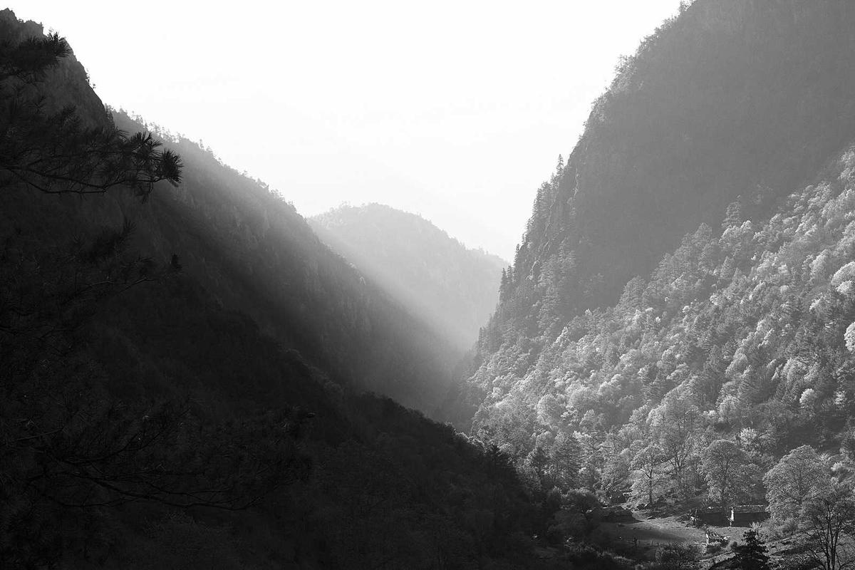 Black and white mountain valley with dramatic light