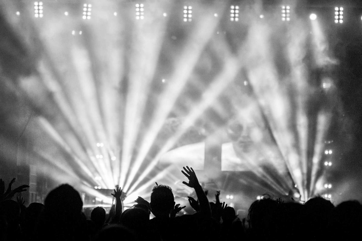 Stage light beams cutting across a packed venue