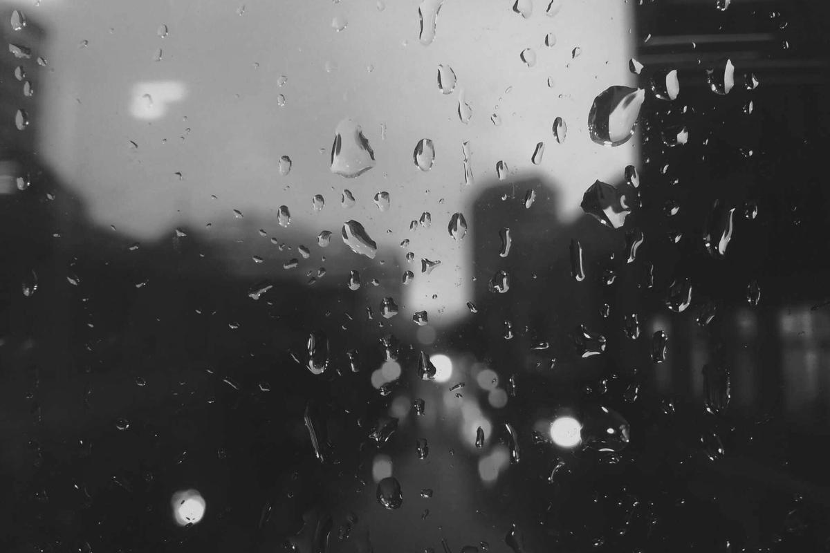City lights blurred through a rain-covered window at night