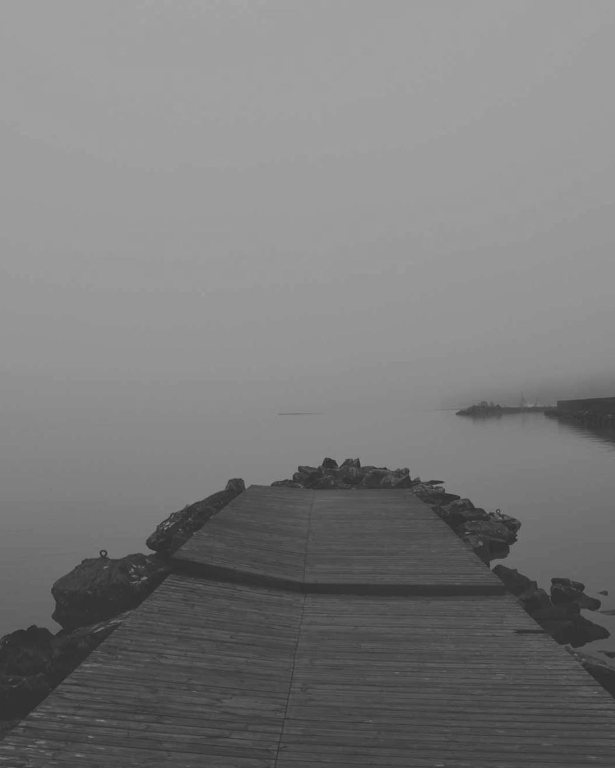 Wooden jetty disappearing into sea mist